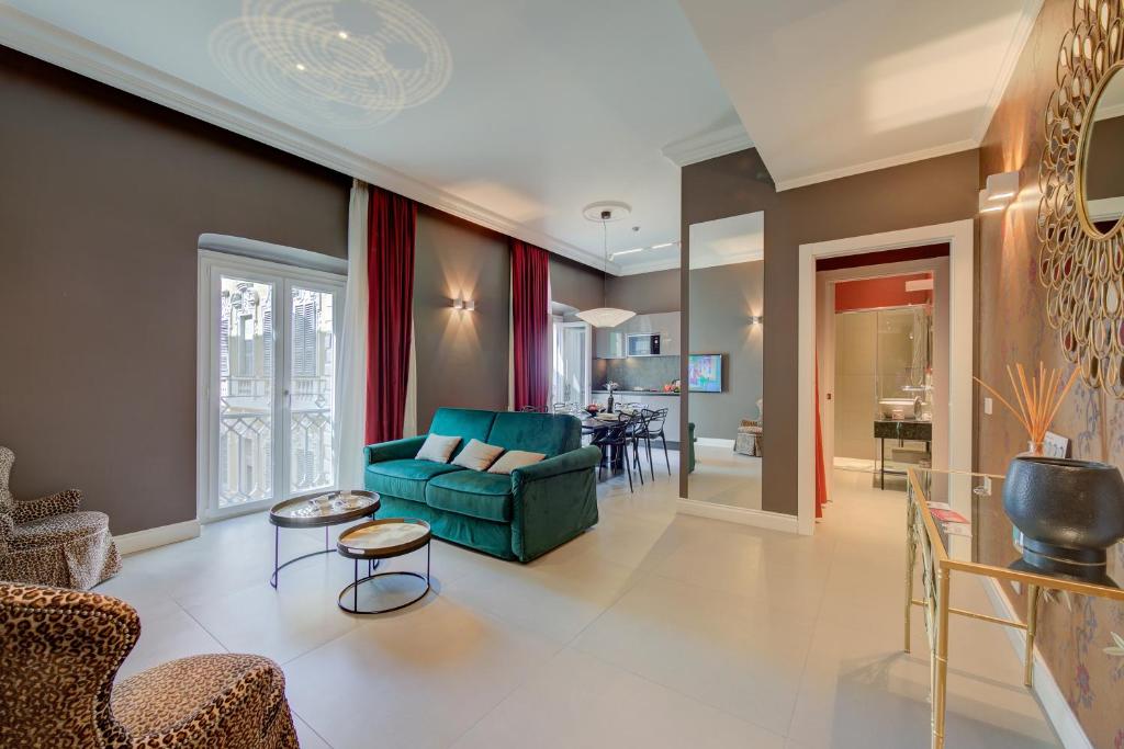 sala de estar con sofá verde y sillas en Boutique Central Apartments- Happy Rentals en San Remo