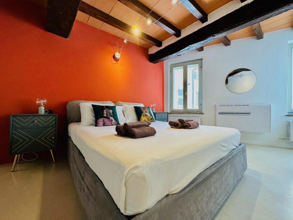 un grande letto in una stanza con una parete arancione di New Street House a Parma
