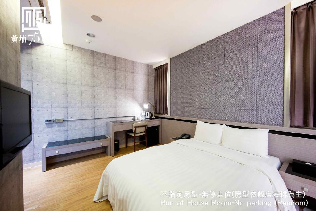 Pokój hotelowy z łóżkiem i biurkiem w obiekcie Military 75 Hotel w mieście Taizhong