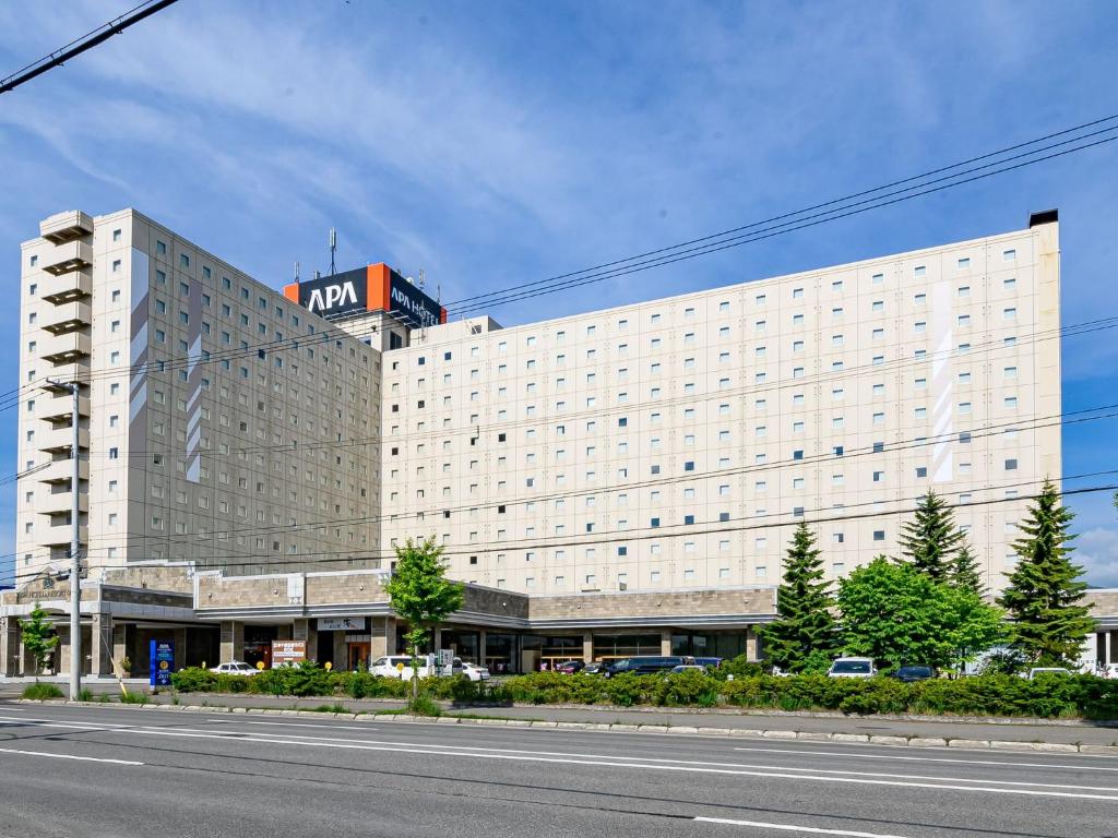 un gran edificio blanco con un cartel encima en APA Hotel & Resort Sapporo en Sapporo