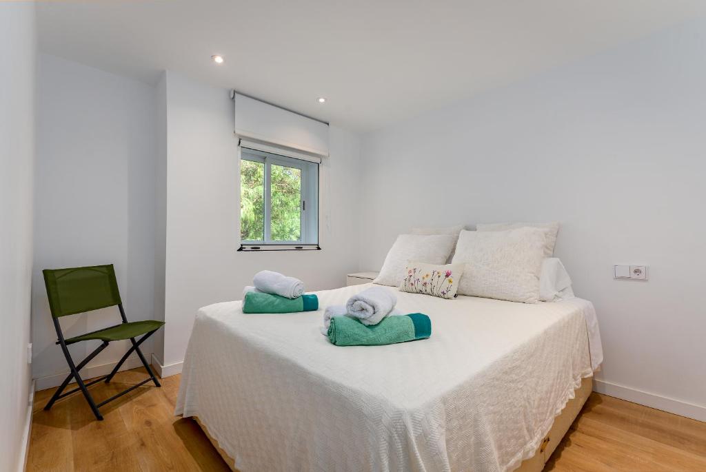 Un dormitorio con una cama blanca con toallas. en Golden Bay Apartment en Estepona