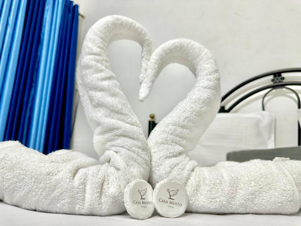 two towels shaped like swans sitting on a bed at Sober 2bhk Pet Friendly Apartment with pool view in Marmagao