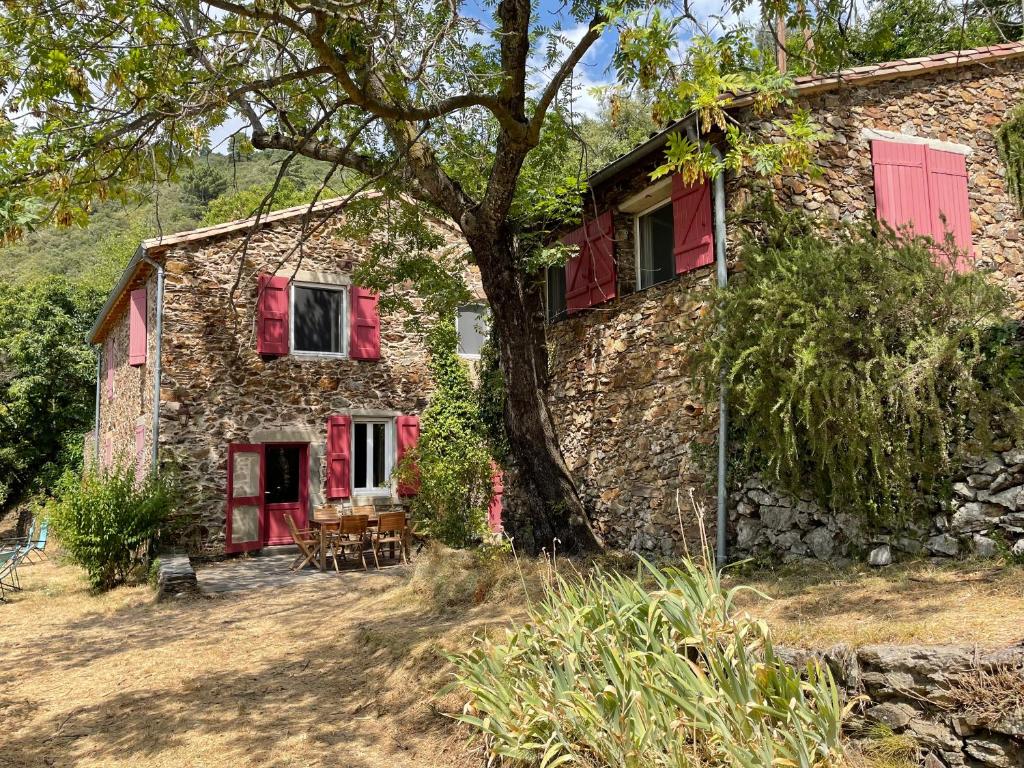une ancienne maison en pierre avec des fenêtres rouges à volets dans l'établissement La Bellevue, à Valleraugue