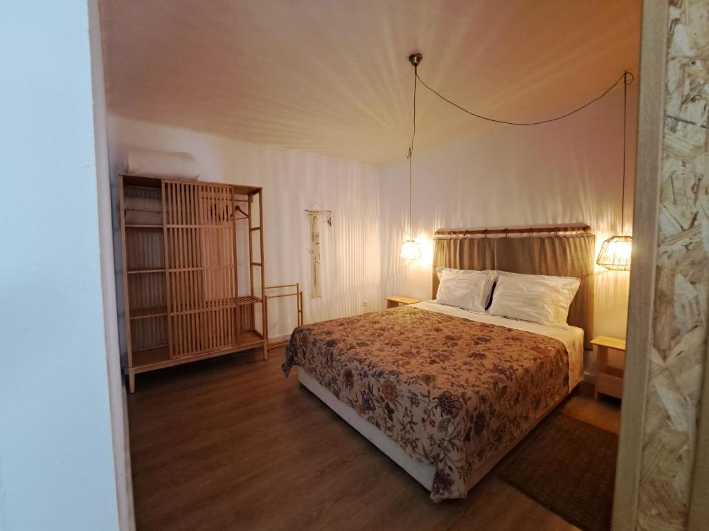 a bedroom with a bed with two pillows and two lamps at Casa Hurtere in Horta