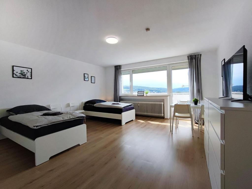 - une chambre avec 2 lits, une télévision et une table dans l'établissement Chic Apartment with balcony, à Bad König