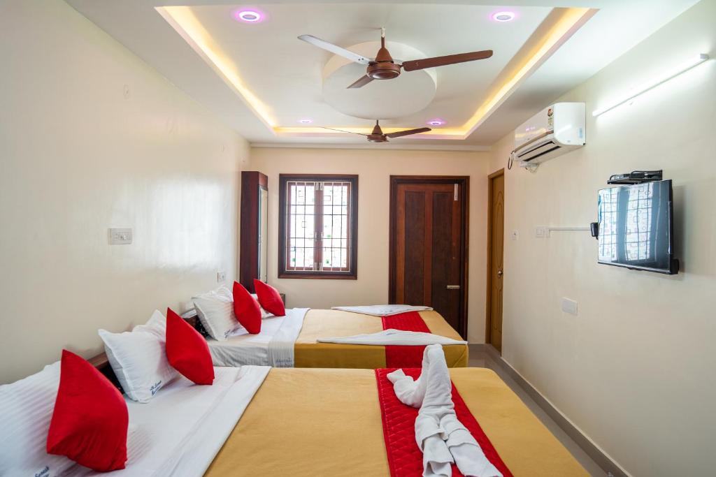 a bedroom with two beds and a ceiling fan at Le Suresh Guest House in Pondicherry