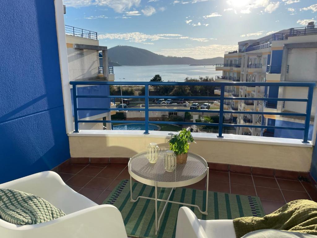 a balcony with a table and a view of the water at Apartamento con vistas al mar B3 Urb Puerto Azul in Cedeira