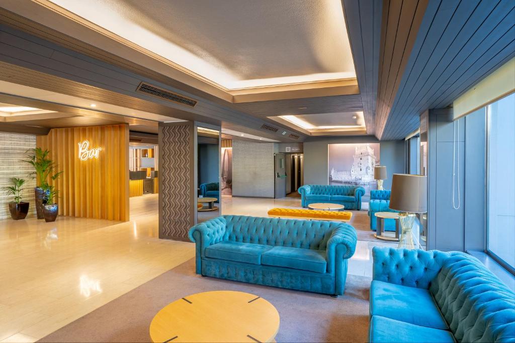 a lobby with blue couches and a table at HF Tuela Porto in Porto