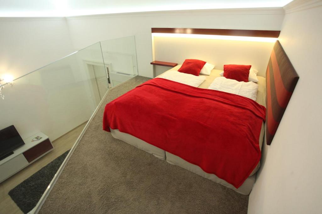 a bedroom with a large red bed with red pillows at Superior Loft at Basilica in Budapest