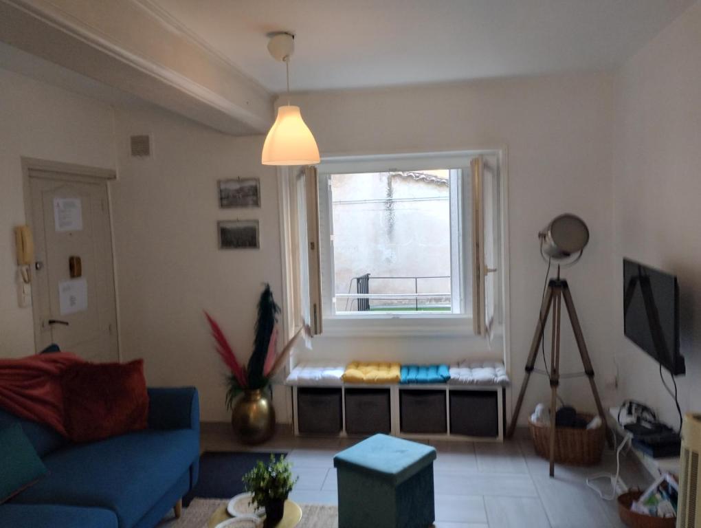 een woonkamer met een blauwe bank en een raam bij ABSL Appartement in Villefranche-sur-Saône