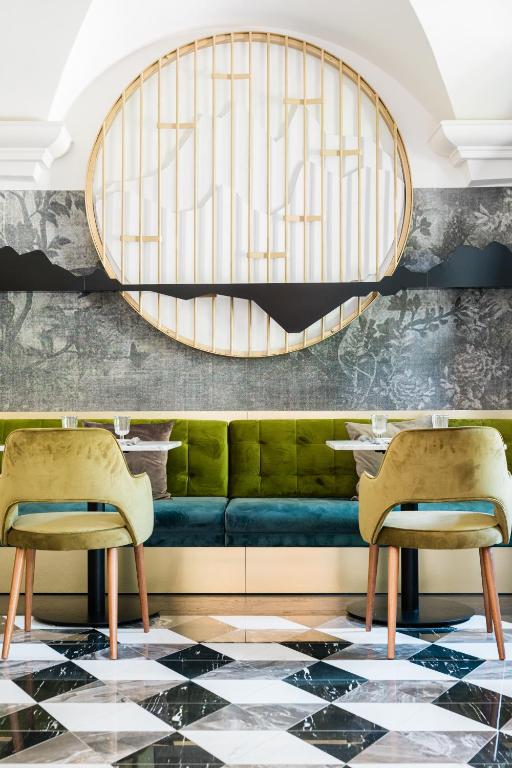 a dining room with a green couch and two chairs at Villa Zara Boutique Hotel Resort in Smolník