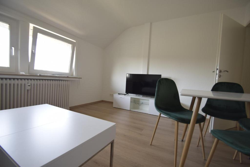 een woonkamer met 2 groene stoelen en een tv bij Air Apartments 13 in Bremen