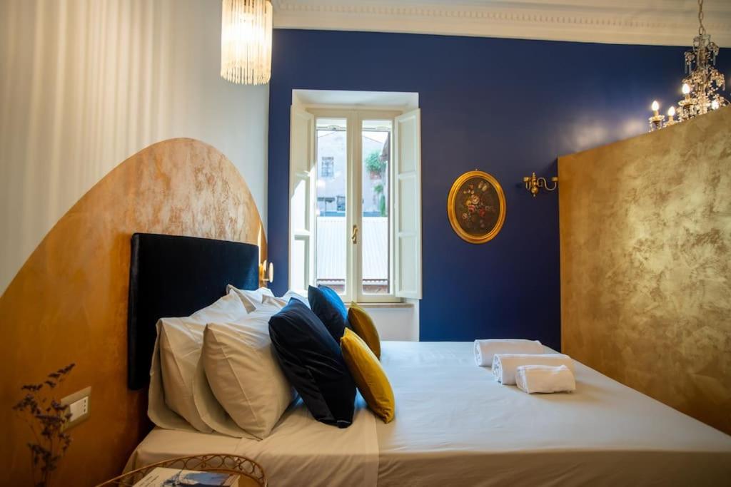 een slaapkamer met een groot bed met blauwe muren bij PgRhome Luxury Apartments Colosseo 11 BLU in Rome