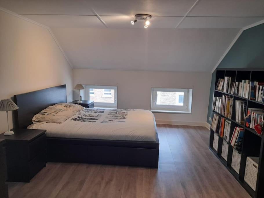 a bedroom with a bed and a book shelf at Appartement 2 chambres à Theux in Theux