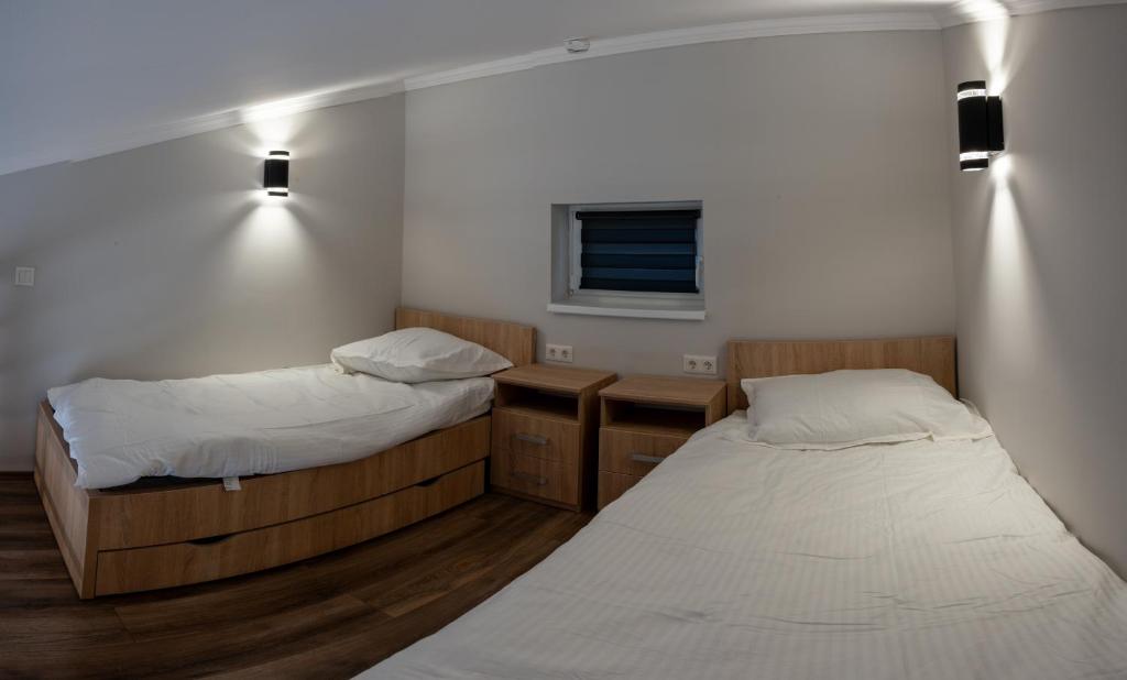 ティサウーイバーロシュにあるTisza Apartのベッド2台、デスク、窓が備わる客室です。