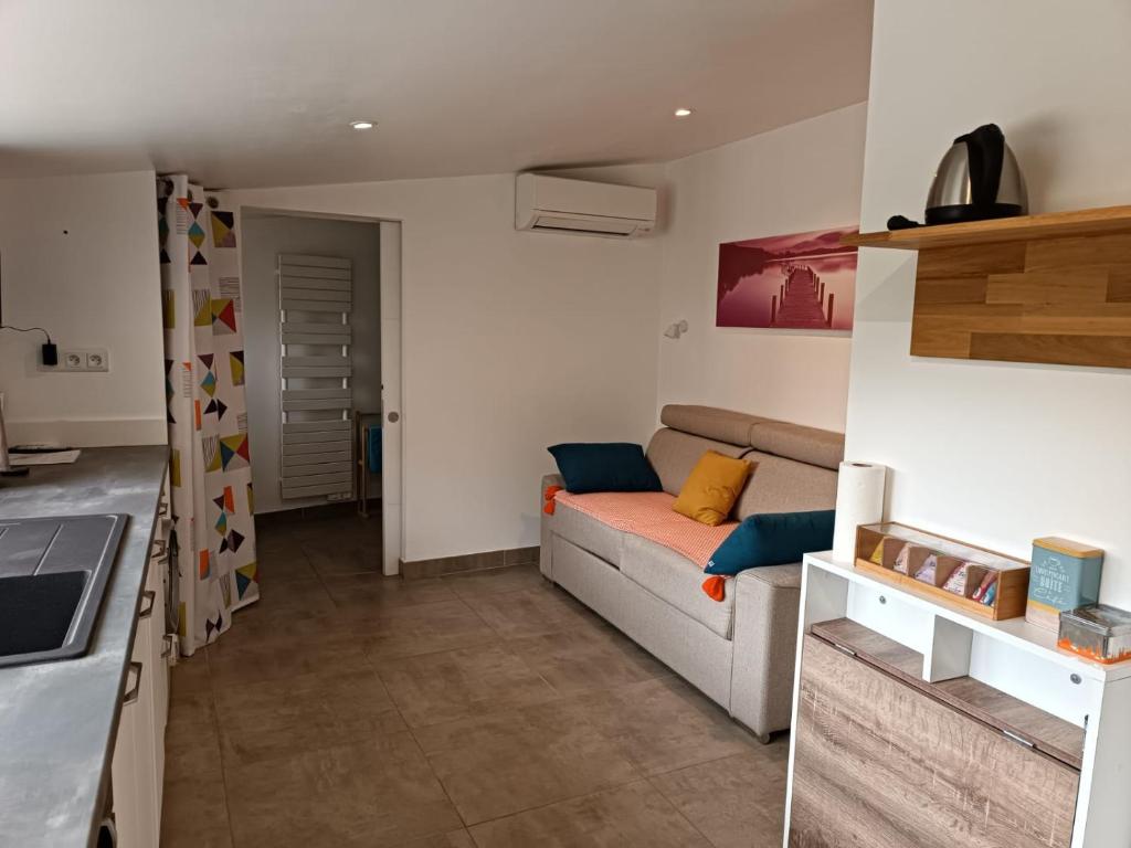 un salon avec un canapé et une cuisine dans l'établissement Studio en Provence avec accès à la piscine de la propriété, à Velleron