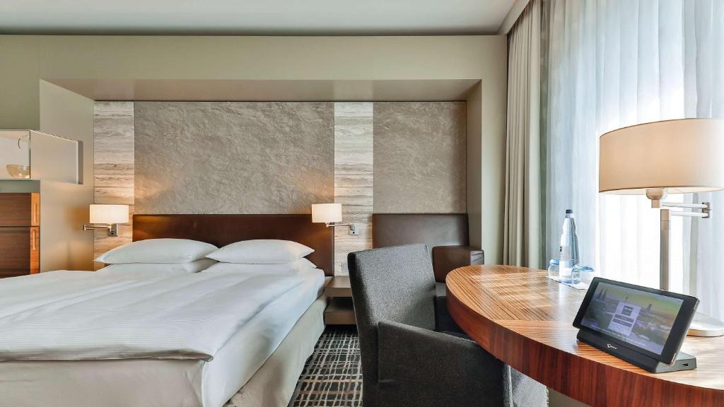 a hotel room with a bed and a desk with a computer at Dorint Hotel am Heumarkt Köln in Cologne