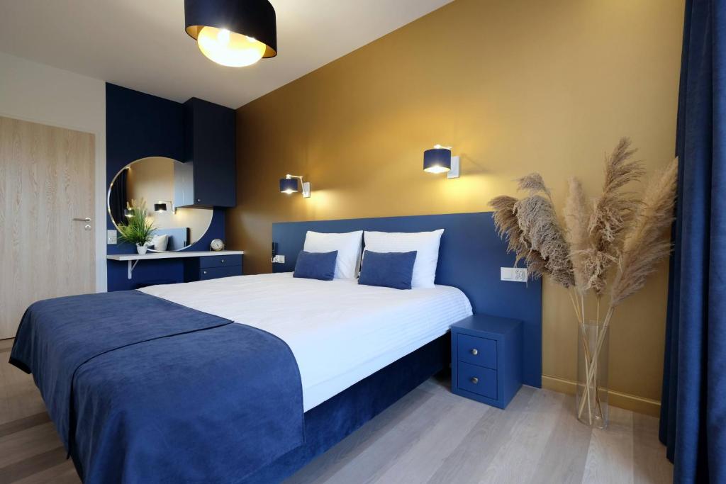 - une chambre avec un grand lit aux murs bleus dans l'établissement Apartamenty Centrum Premium Gold, à Białystok