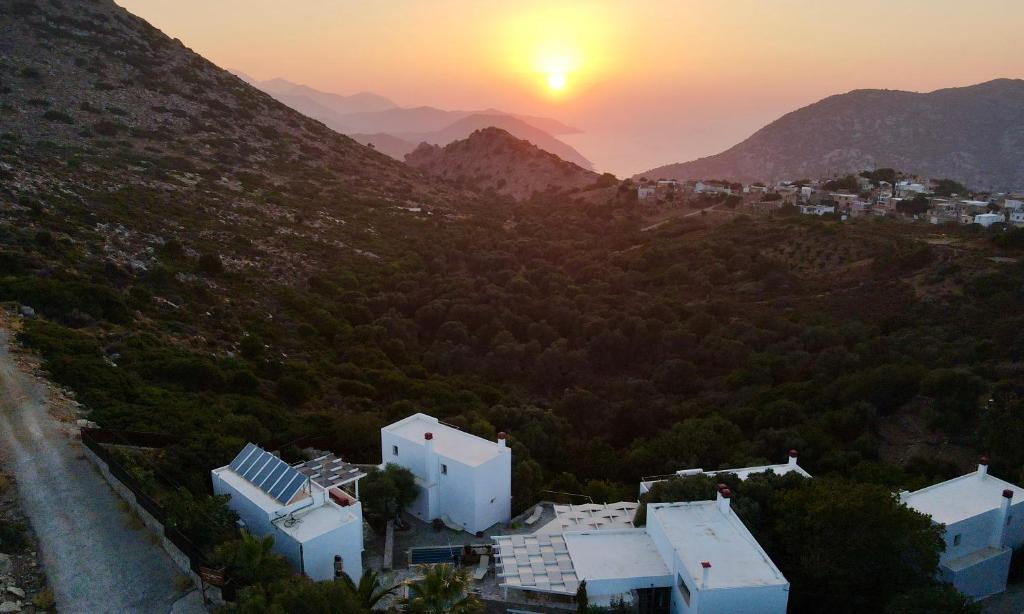 a sunset over a mountain with houses and trees at Mourtzanakis Residence - Traditional Eco Hotel in Achlada in Achlada