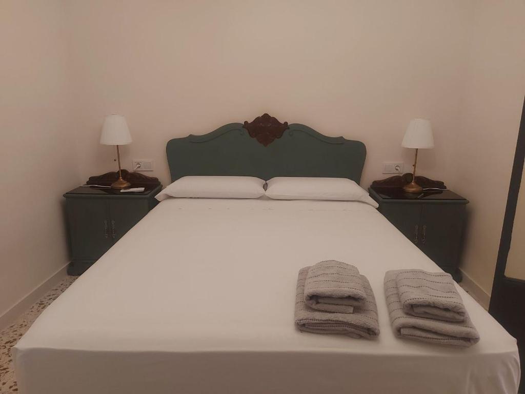 a bedroom with a large white bed with two night stands at Balcón de Aguilar in Aguilar de la Frontera