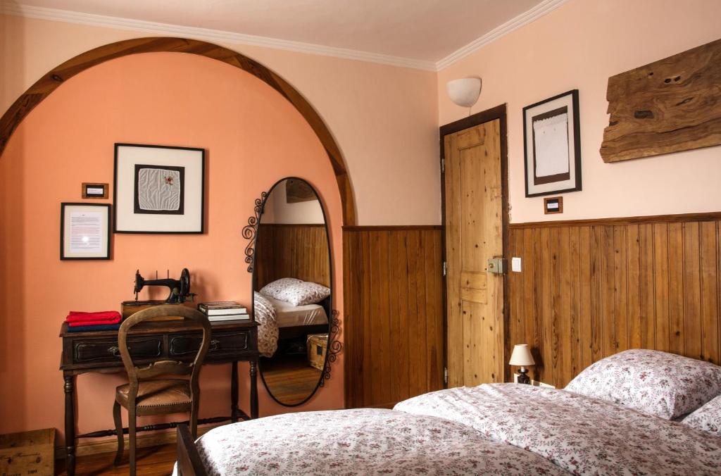a bedroom with two beds and a mirror and a desk at Sintra Small Hostel in Sintra