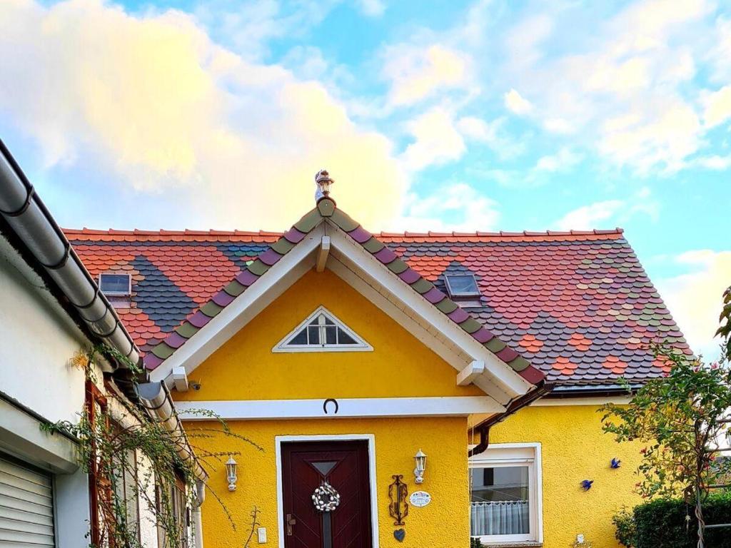 ein gelbes Haus mit rotem Dach in der Unterkunft A. Heyne in Weinböhla