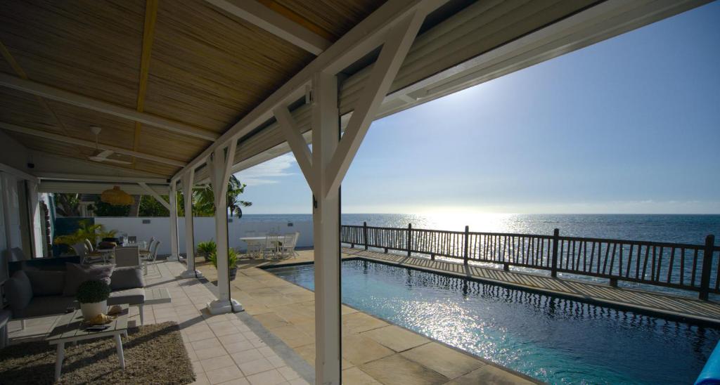 a swimming pool with a view of the ocean at Serenity by the Sea- 3BRVilla w Stunning Sunsets in Tamarin