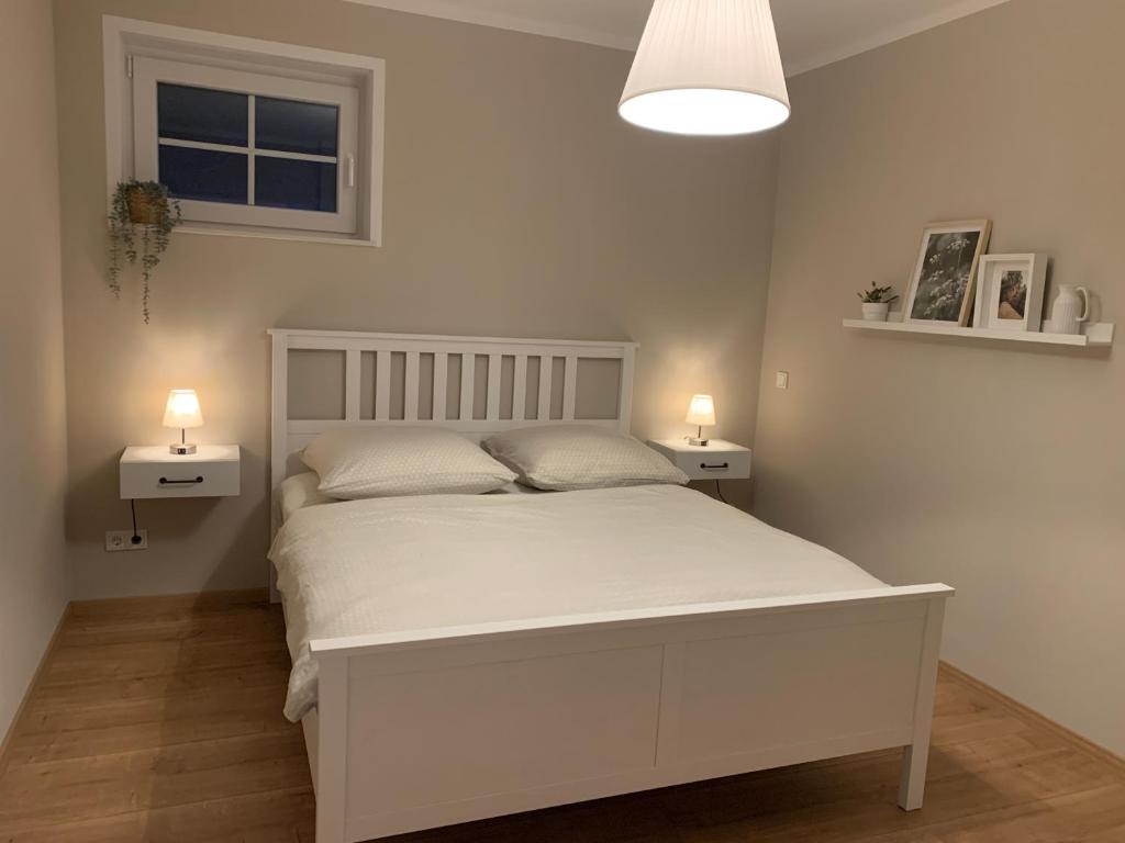 1 dormitorio con 1 cama blanca y 2 mesitas de noche en Ferienwohnung Schöne Aussicht in Simmertal, en Simmertal