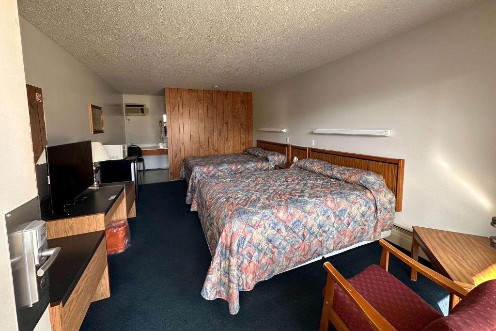 a hotel room with a bed and a television at Howard Johnson by Wyndham Edson in Edson