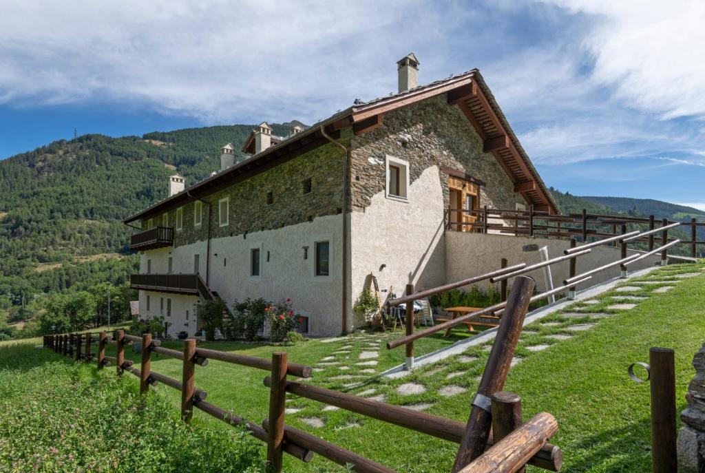 a house on a hill with a fence at Maison Marcoz - Appartamenti vacanze in Etroubles