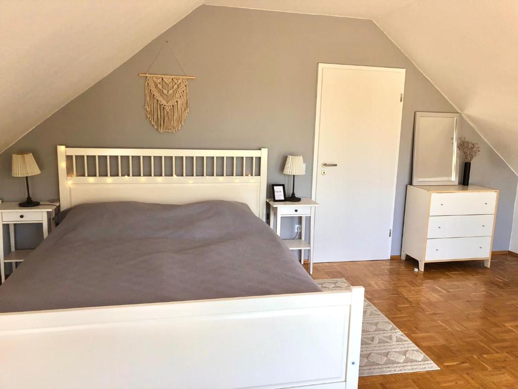 a bedroom with a white bed and a white closet at Ferienwohnung Skandi in Bad Eilsen