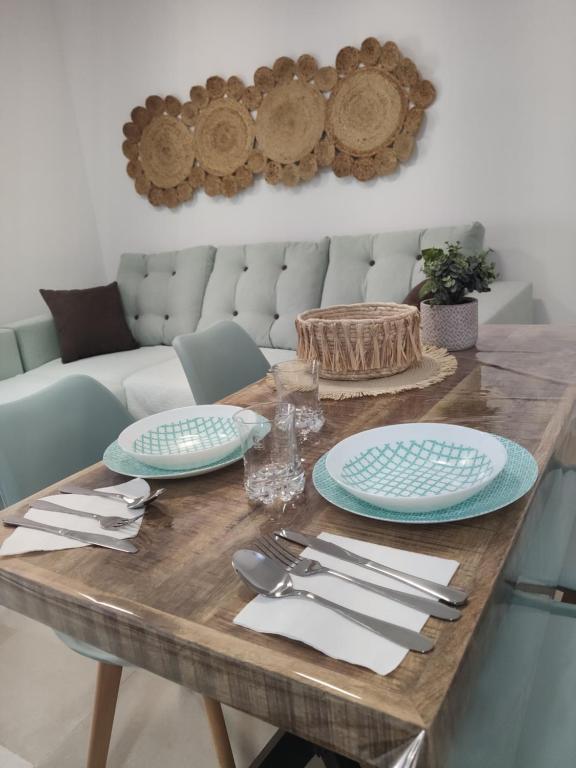 a wooden table with plates and silverware on it at SUDAMERICA38 in Roquetas de Mar