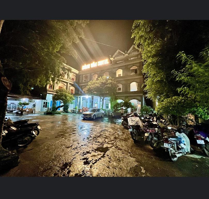 une rue pluvieuse avec des motos garées devant un bâtiment dans l'établissement Khách Sạn Hùng Vân, à Ha Giang