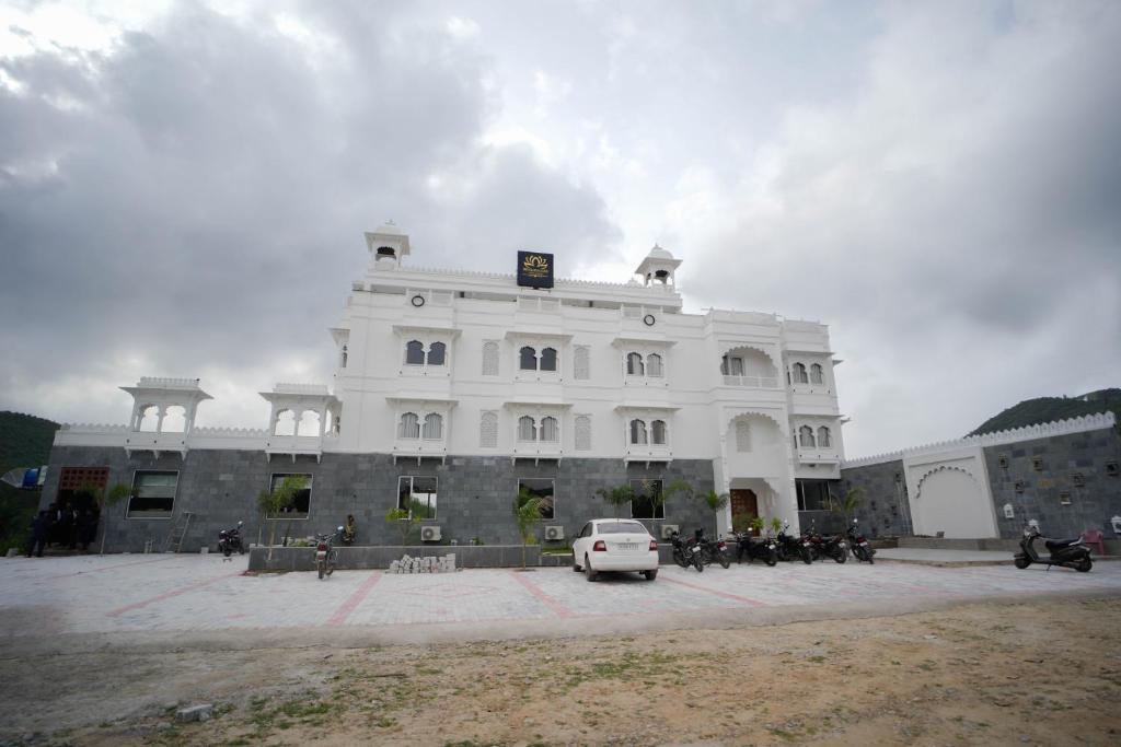 a white building with a car parked in front of it at The Ekling Garh Hotel & Resort in Udaipur