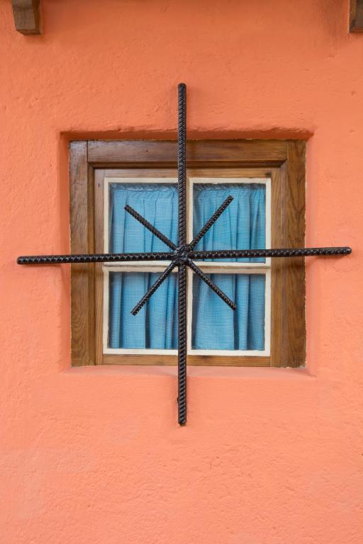 a cross on the side of a building with a window at Sintra Small Hostel in Sintra