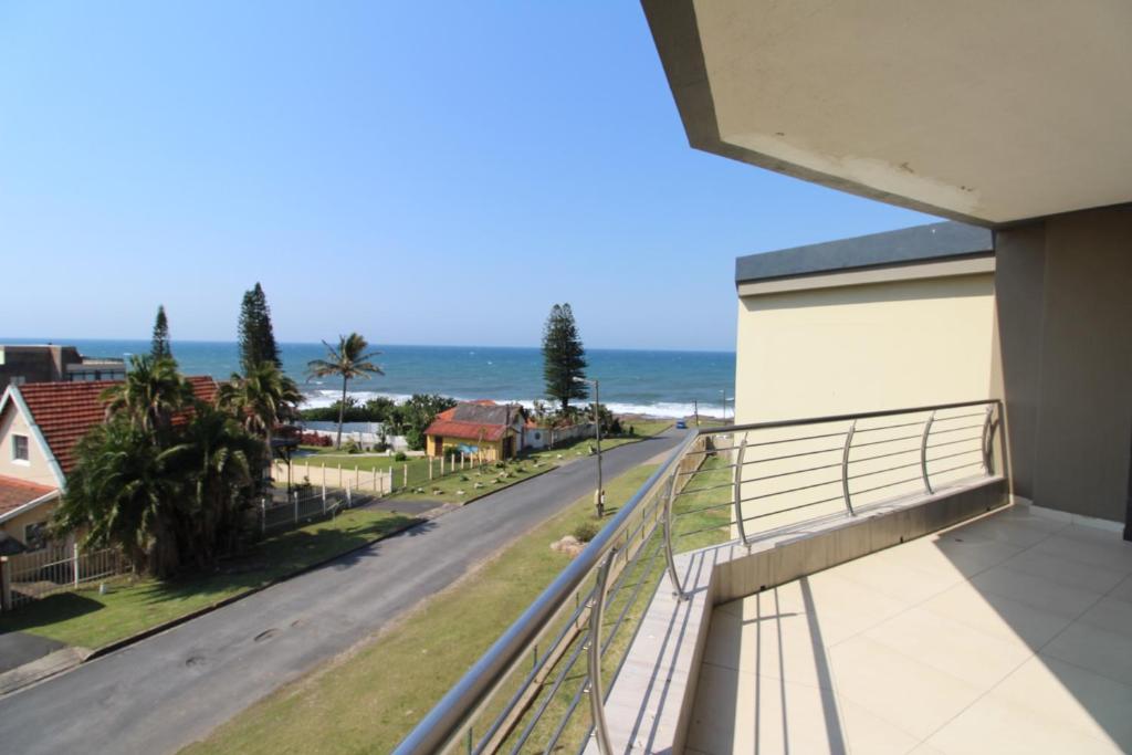 uma varanda com vista para uma rua e para o oceano em Saints View Resort Unit 17 em Uvongo Beach