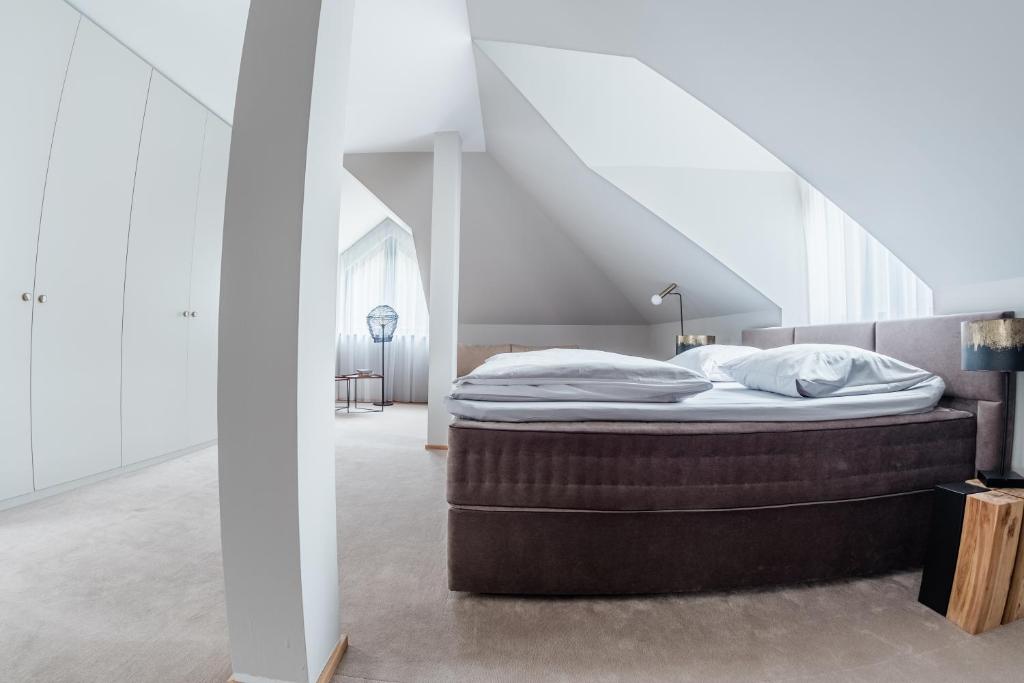 una cama en una habitación con escalera en Villa Zara Boutique Hotel Resort, en Smolník