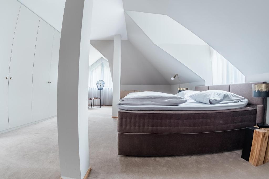 a bed in a room with a staircase at Villa Zara Boutique Hotel Resort in Smolník