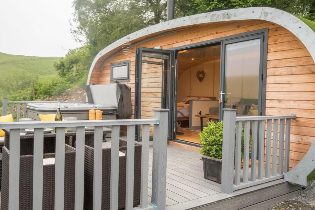 a small wooden cabin with a large glass door at Fern - Beacon View Pods in Knighton