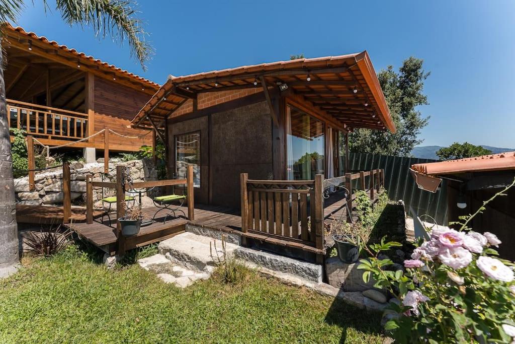 Cette maison en bois dispose d'une terrasse couverte. dans l'établissement Fernandes Guest House Green Bungalow, à Ponte de Lima