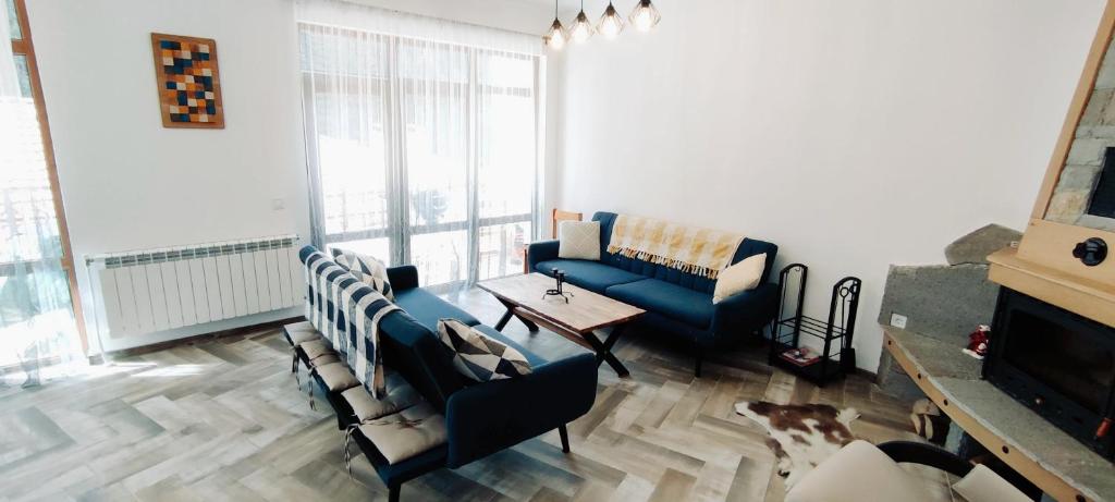 uma sala de estar com um sofá azul e uma mesa em Mountain Pearls Home 8 em Vodata