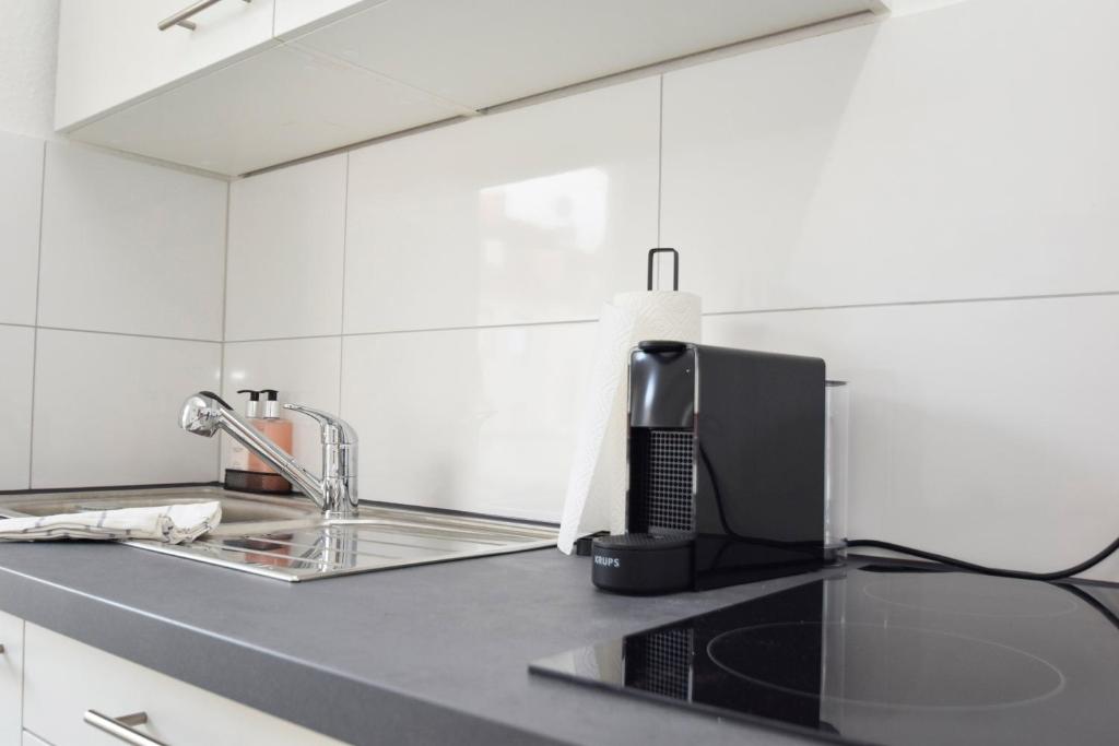 - un comptoir de cuisine avec évier et four micro-ondes dans l'établissement Air Apartments 4, à Brême