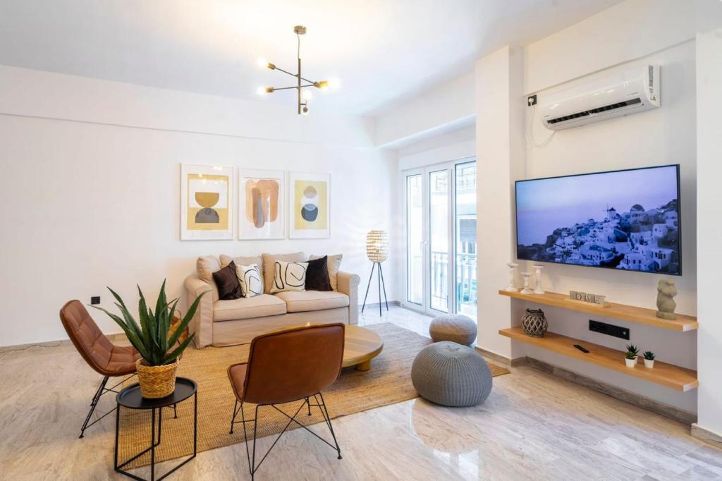 een woonkamer met een bank en een flatscreen-tv bij Modern flat in Kolonaki in Athene