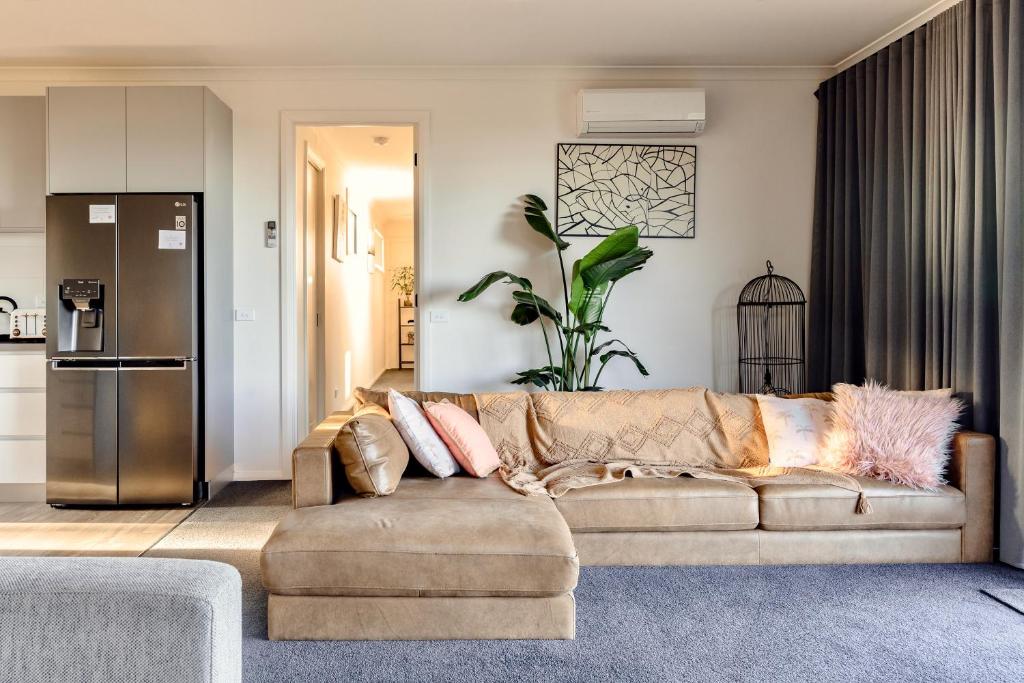 sala de estar con sofá y cocina en Wamoon Retreat - Luxe House, en Yanakie