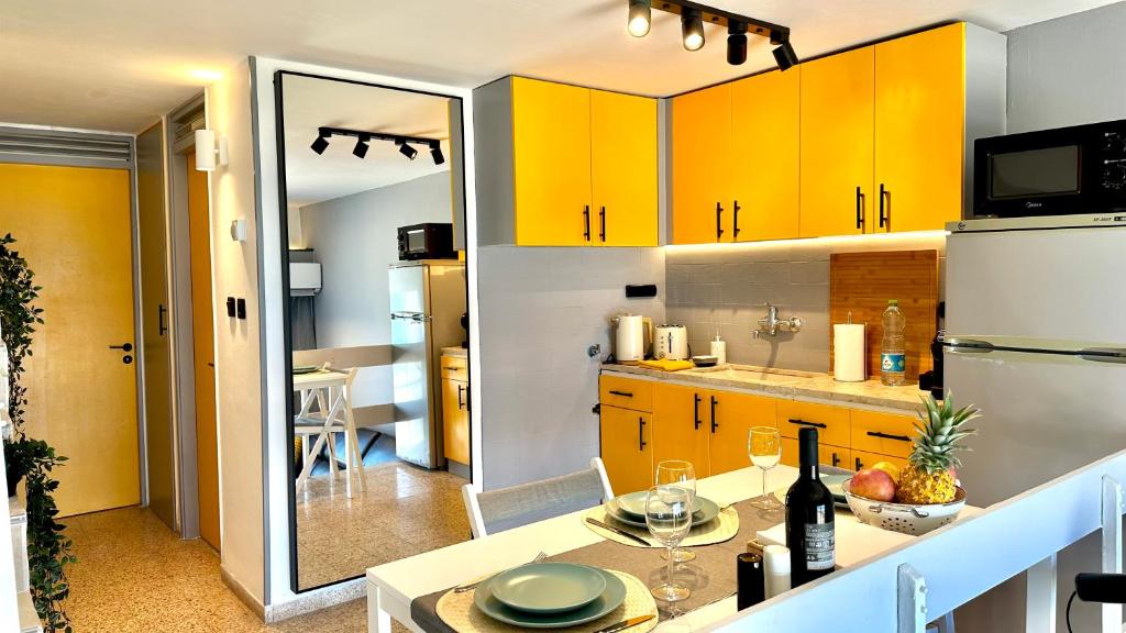 cocina con armarios amarillos y nevera blanca en GW317 Gugel Waves Amazing Seaview Pool Apartments, en Nahariyya