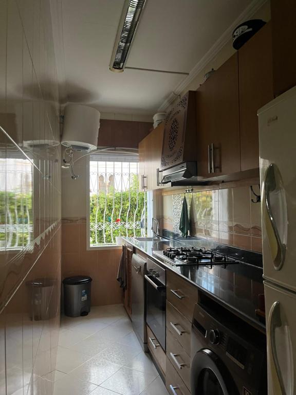 uma cozinha com um fogão, um lavatório e uma janela em Tanger , Merchan em Tânger