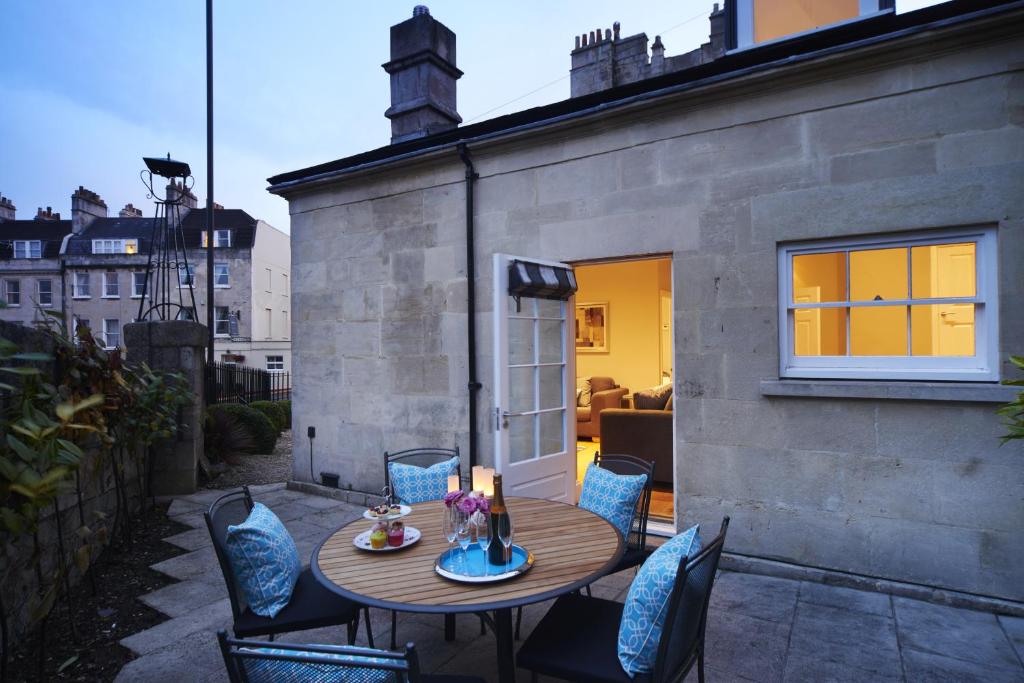 un pequeño patio con mesa de madera y sillas en Bath Circle Camden Lodge House, en Bath