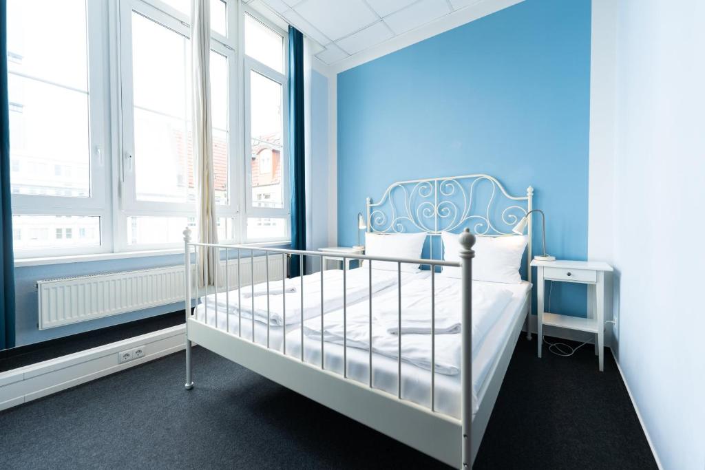 um quarto com uma cama e uma parede azul em Industriepalast Berlin em Berlim