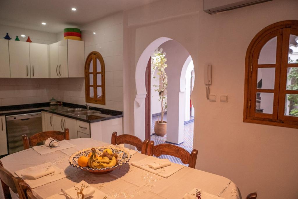舍夫沙萬的住宿－Lalla Ghayta，厨房配有一张桌子,上面放着一碗水果