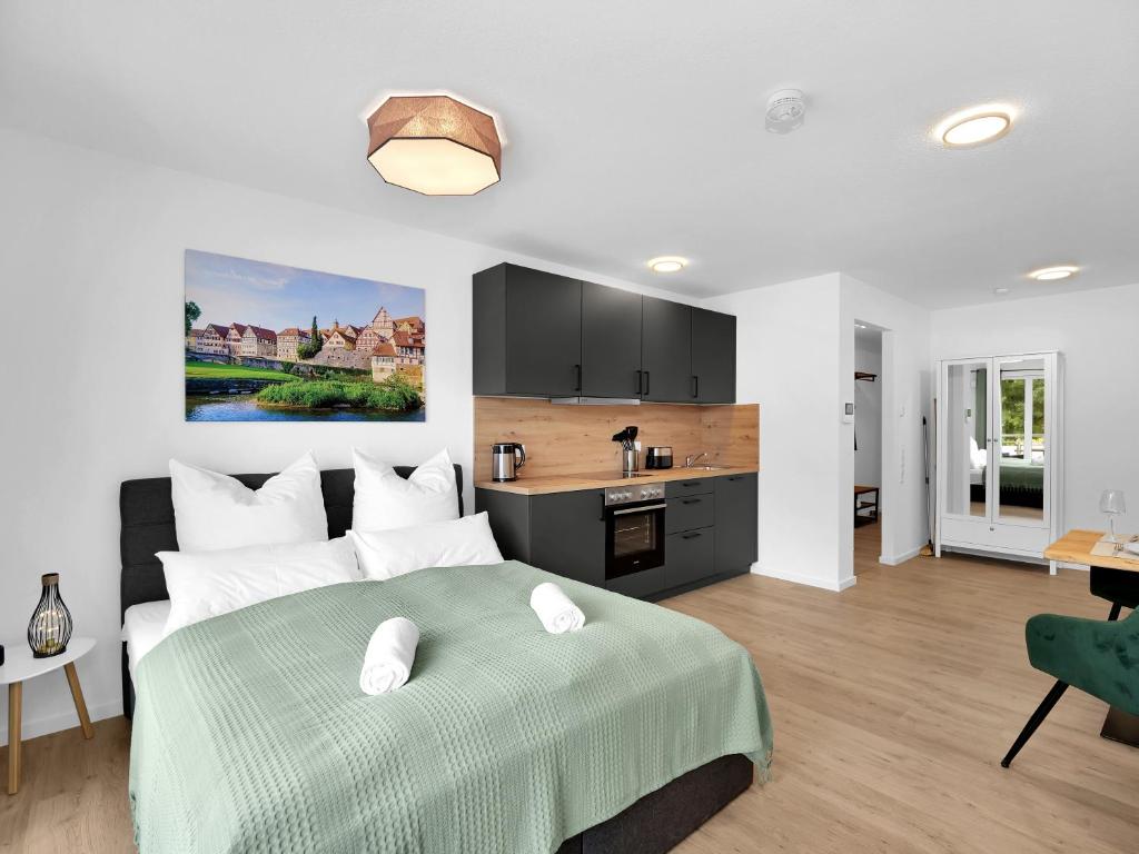 a bedroom with a large bed and a kitchen at INhome Studio Apartment - Küche - Parken - TV in Schwäbisch Hall